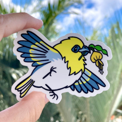 Sticker cartoon illustration of a native Hawaiian Honeycreeper, the palila, with a mamane sprig and blossom in its beak as it flies by smiling.