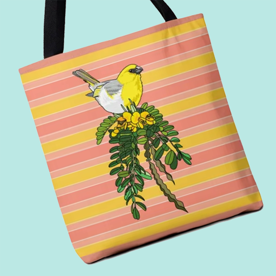 An illustration of a palila, a yellow, white, and gray Hawaiian honeycreeper perched on a yellow blooming mamāne branch, centered on a striped yellow and pink tote bag